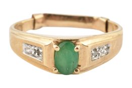 A 10k gold emerald and diamond ring. The ring set with a central oval cut emerald to diamond set