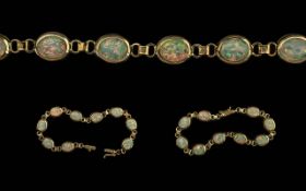 A 9ct Gold and Opal Bracelet, nine opals inter spaced with gold links. Two extra links included.