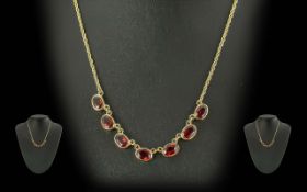 Ladies 9ct Gold Necklace, set with seven oval garnets, on rope twist chain. Weight 7.7 grams.