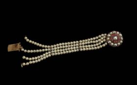 An Antique Pearl & Ruby Bracelet in a Gold Mount, four rows of pearls approx. 4.5mm diameter pearls.