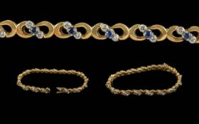 18ct Gold Fancy Link Bracelet, each link set with Round Diamonds and blue faceted stones, stamped