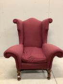 A Queen Anne revival wing armchair with wide scroll arms on turned walnut underframe, width 106cm,