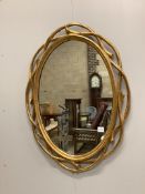 A Contemporary gilt composition oval wall mirror, with branch effect border, width 74cm, height