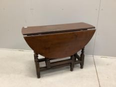 An 18th century oak gateleg table with an oval top on baluster turned under frame, 112cm extended,