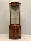 A reproduction Sheraton style inlaid mahogany bow fronted standing corner cupboard, width 70cm,