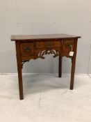 A mid 18th century walnut lowboy quarter veneered with a rectangular top above three drawers and a