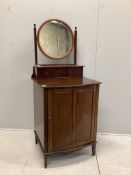 An early 20th century mahogany bowfront dressing chest, with bevelled plate circular mirror, and