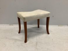 A mahogany dressing stool with square splayed legs and an overstuffed seat covered in green
