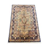 A Kerman carpet, with central medallion and field of floral motifs within a shaped floral border,