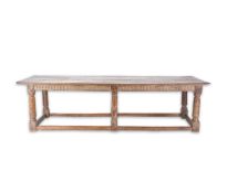 A 17th century style oak and elm refectory table with cleated top, carved frieze and six turned legs