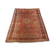 An antique Qashquai red ground carpet, with triple medallions and foliate motifs on a shaped