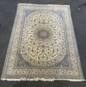 A Tabriz cream ground carpet woven with scrolling flowers and leaves, in blue and red, 470 x 317cm