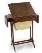 A Regency crossbanded satinwood writing and work table with twin flap folding top enclosing a