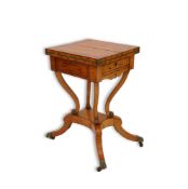 A Regency rosewood banded ebony inlaid satinwood patience table with twin hinged flap top over baize
