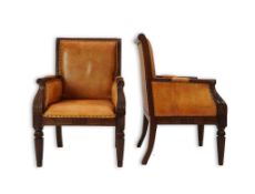A pair of early 19th century Anglo Indian carved mahogany armchairs with tan leather upholstered