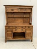 A small Arts & Crafts copper mounted oak dresser, width 140cm, depth 48cm, height 182cm. Condition -