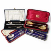 Three assorted cased George V silver christening sets and a cased pair of silver serving spoons,