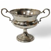 A white metal two handled pedestal trophy cup, stamped 'Barton silver', engraved with the letter