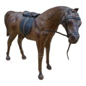 A Liberty style leather covered model horse, 53cm wide. Condition - poor/fair