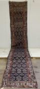 An antique Caucasian blue ground runner, approximately 500 x 91cm. Condition - poor