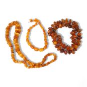 Three assorted amber necklaces including a single strand graduated oval bead necklace, 40cm, gross w