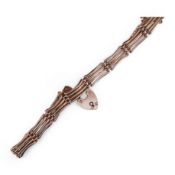 An early 20th century yellow metal gate link bracelet, with heart shaped padlock clasp on safety cha