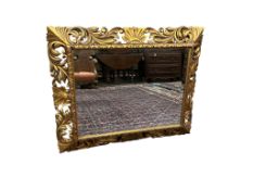 A rectangular carved giltwood Florentine style wall mirror with bevelled plate, width 110cm, height