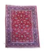 A Kashan burgundy ground carpet