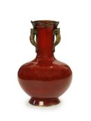 An unusual Japanese sang-de-boeuf ground cloisonné enamel and gilt metal mounted vase