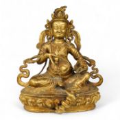 A large Sino-Tibetan gilt-bronze seated figure of Jambhala, 28cm high