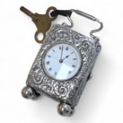 An early 20th century white metal (tests as silver) carriage timepiece, with white Roman dial (