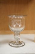 A large George III glass goblet, with inset coins to the hollow ball knopped stem, engraved with a