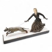 An Art Deco French spelter and ivorine model ‘Walkies Lady and Dog’, on a black marble and cream