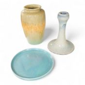 A Ruskin souffle glazed vase, impressed 1932, a Ruskin circular dish and an earthenware candlestick,