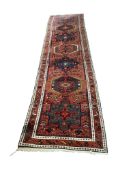A Karaja runner, the red field with six medallions, 335 x 82cm