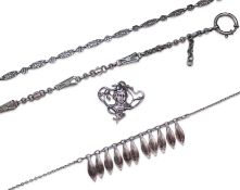 A collection of three silver chains and an Art Nouveau brooch, early 20th century