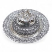 A 20th century Middle Eastern white metal circular dish and cover, embossed with flower heads,