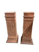 A pair of terracotta pedestals, decorated with panels of scrolling foliage, width 45cm, height