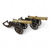 A decorative pair of brass model cannons, with turned barrels, 29cm overall, on cast iron pierced