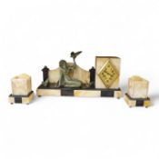 An Art Deco beige onyx and slate clock garniture surmounted with a seated girl holding a bird,