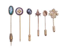 A collection of six stick pins, comprising: three gold stick pins, one set with a hardstone cameo,