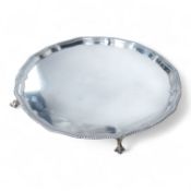 A George V silver salver, of shaped circular form, with gadrooned border, on four claw and ball