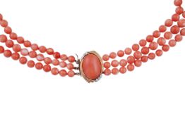 A coral necklace, composed of three strands of coral beads measuring approximately 5.1-6.6mm