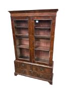 A Queen Anne Revival walnut two door bookcase, the base fitted with drawers, width 92cm, depth 27cm,