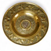 An embossed brass arts and crafts alms charger with inscriptions, 51cm in diameter