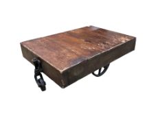 A vintage rectangular wood factory cart with iron spoked wheels now as a coffee table, width
