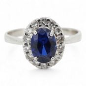 A synthetic sapphire and diamond cluster ring, mounted in white gold, size L1/2, stamped 18K,