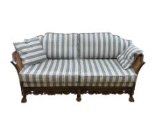 An early 20th century William & Mary style oak bergere settee, with loose cushion seat and back,