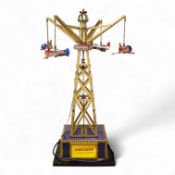 A Meccano model of a fairground ride, incorporating an electric motor in the base and lighting