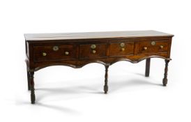 A William and Mary oak low dresser fitted four drawers over an arched shaped apron on turned